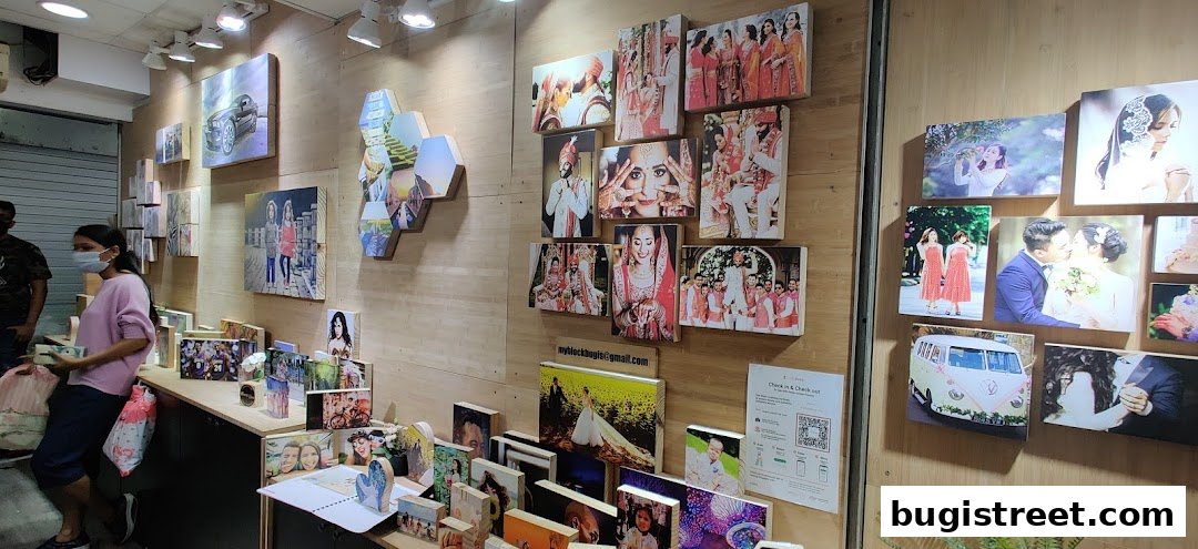 Interior of a shop displaying various photo prints on wooden blocks, including wedding and portrait photography.