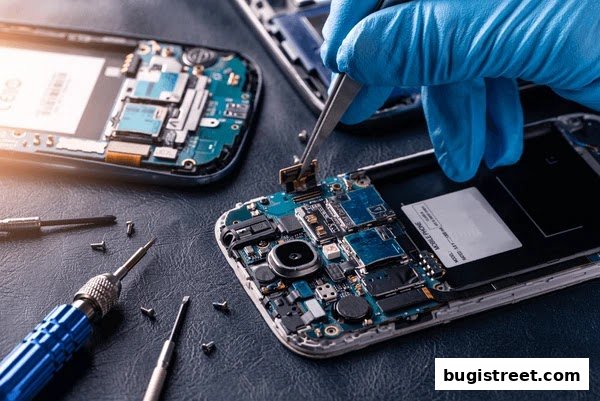 A technician in blue gloves repairs a smartphone with tools and disassembled parts.