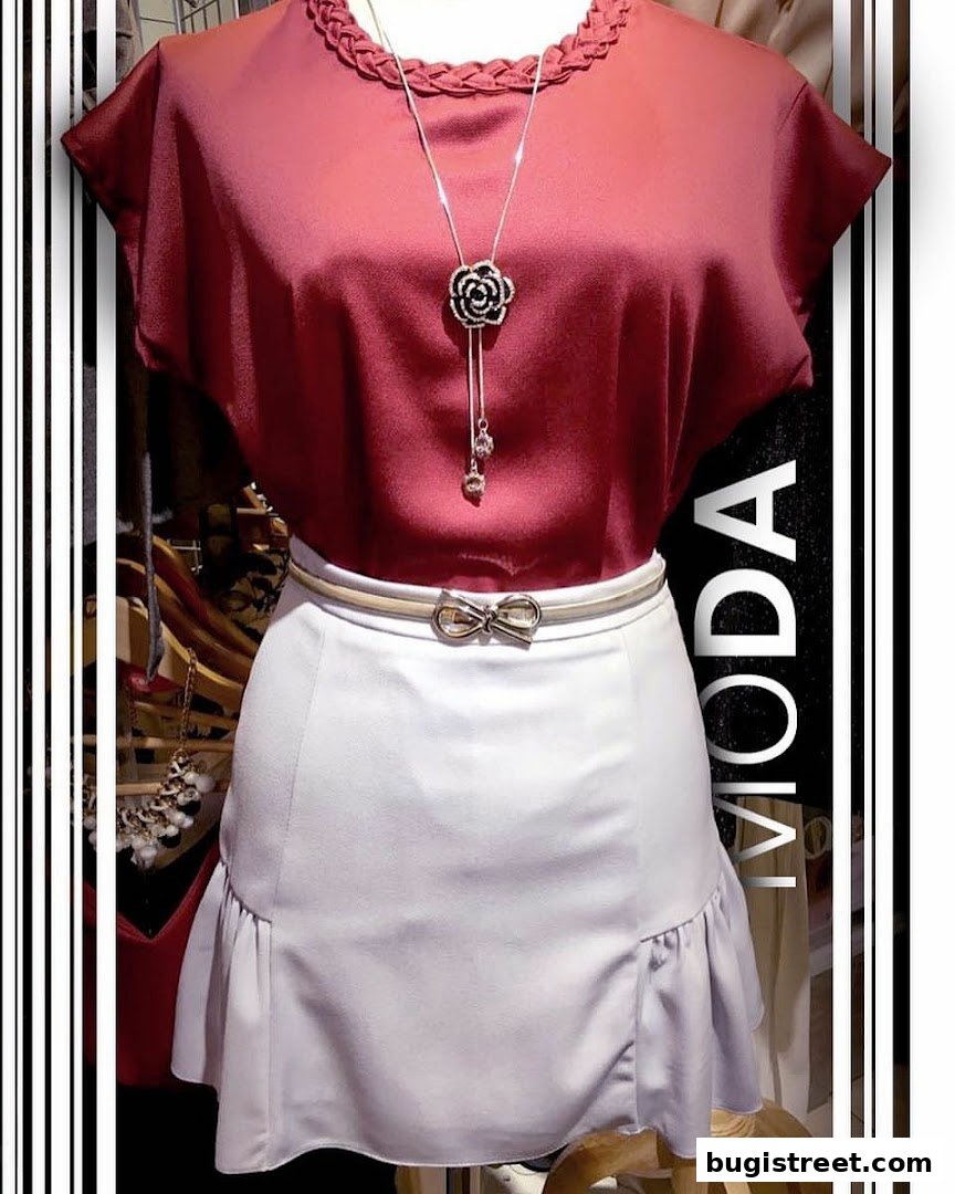 A mannequin displays a stylish outfit with a maroon top, white skirt, and a floral necklace.