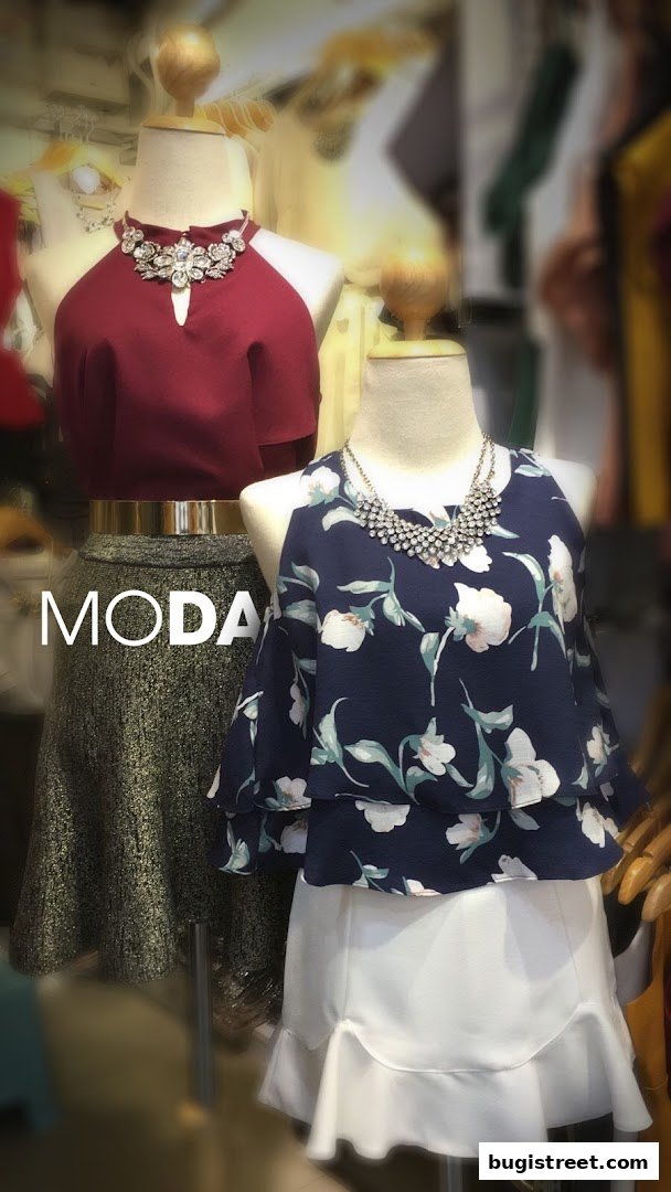 Mannequins display stylish outfits with statement necklaces and fashionable skirts.