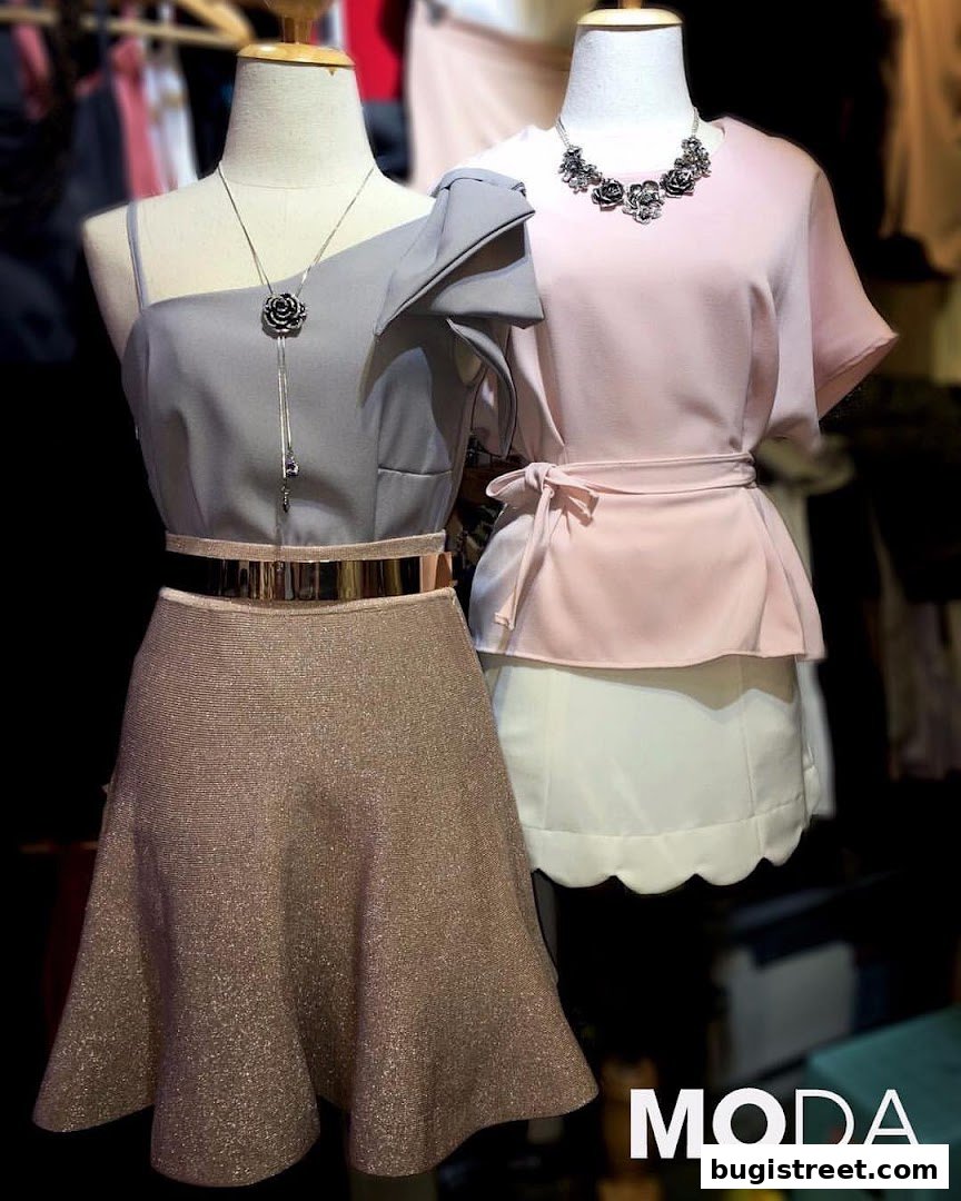 Mannequins display stylish outfits with elegant necklaces and metallic belts at Moda Boutique.