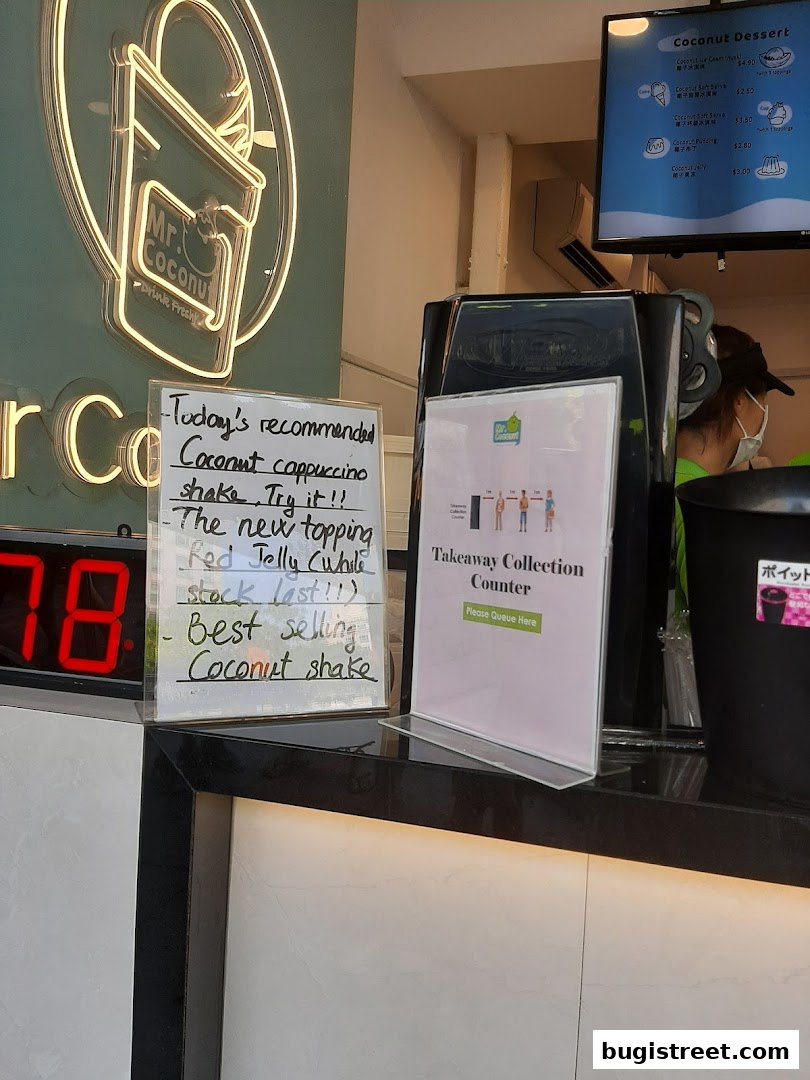 Mr. Coconut shop counter with a neon sign, handwritten recommendations, and a takeaway collection sign.
