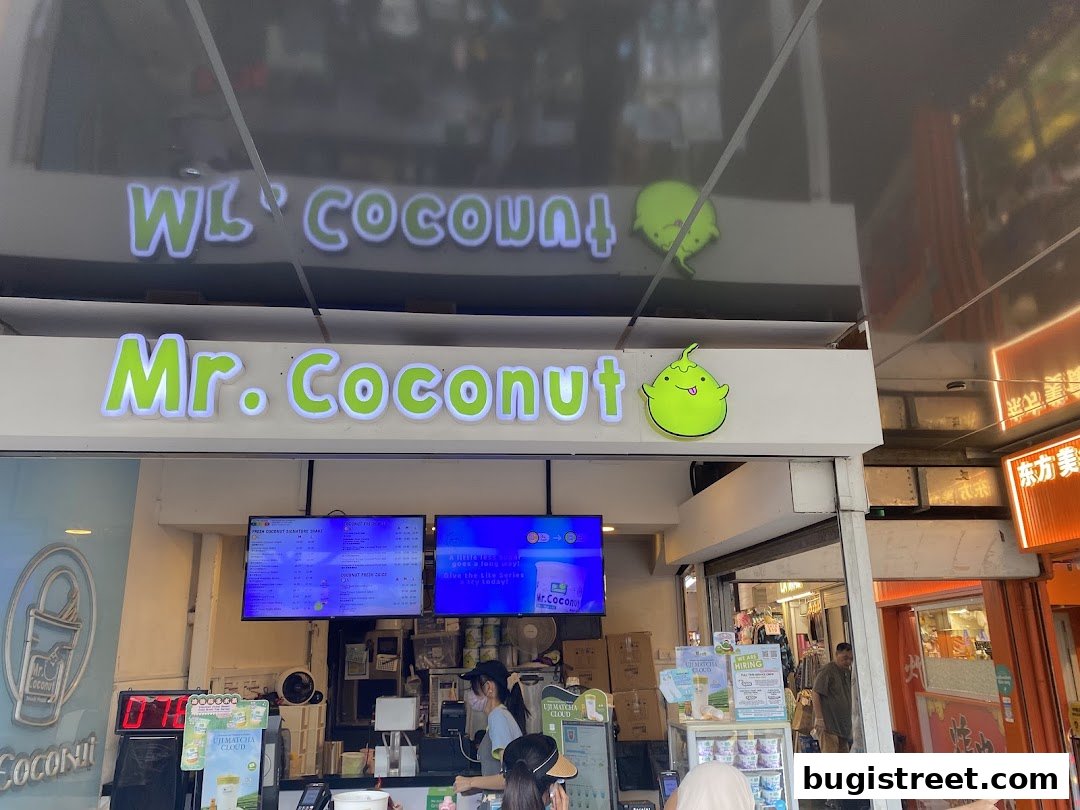 The exterior of a Mr. Coconut shop with its prominent signage and menu displays.