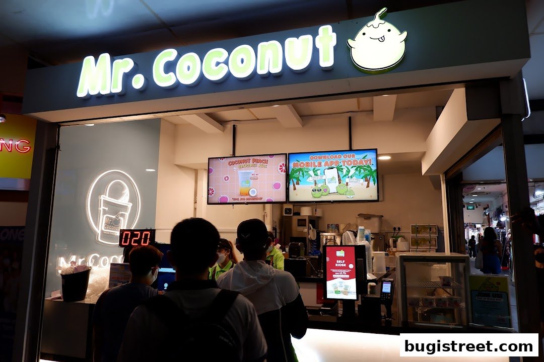 Mr. Coconut shop front with a queue of customers and digital displays.