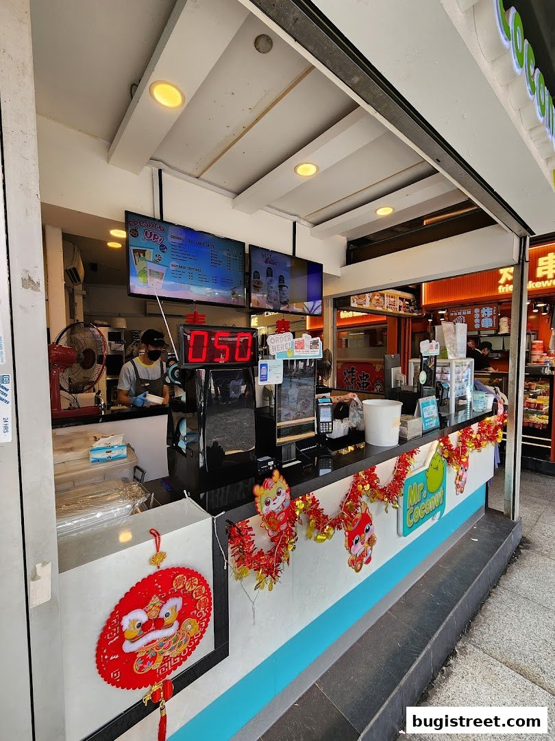 A Mr. Coconut stall decorated with festive Chinese New Year ornaments and a digital display.