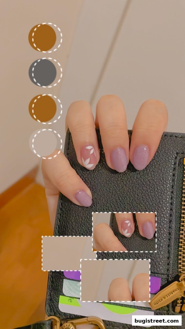 Close-up of a hand with elegant purple nails featuring delicate white leaf designs.