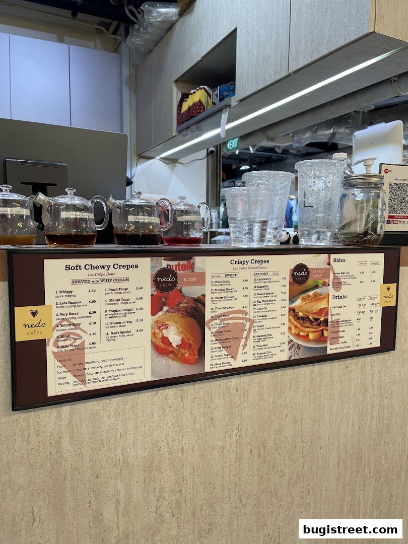 A menu board for Neds Crepes & Coffee, featuring various crepe options and drinks.