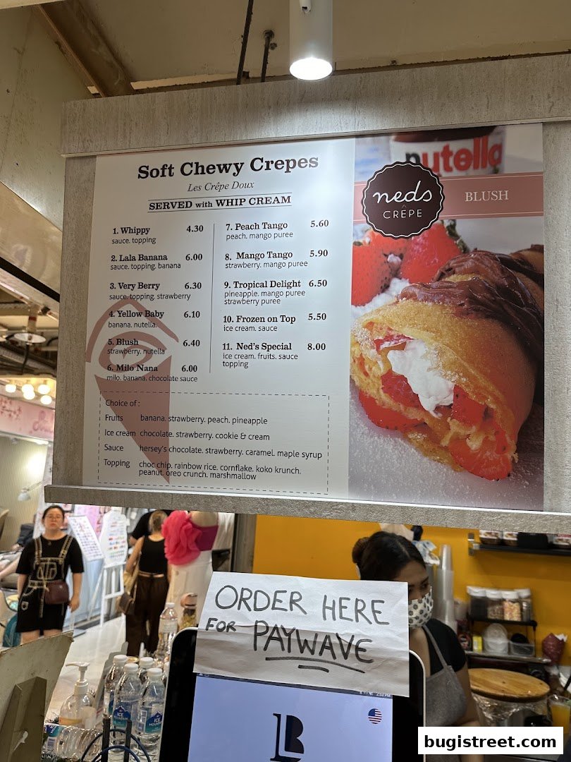 A menu board for Neds Crepes & Coffee, showcasing various crepe flavors and toppings.