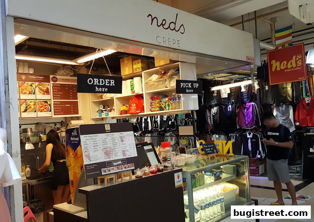 A crepe and coffee shop with a menu, order, and pick-up signs.