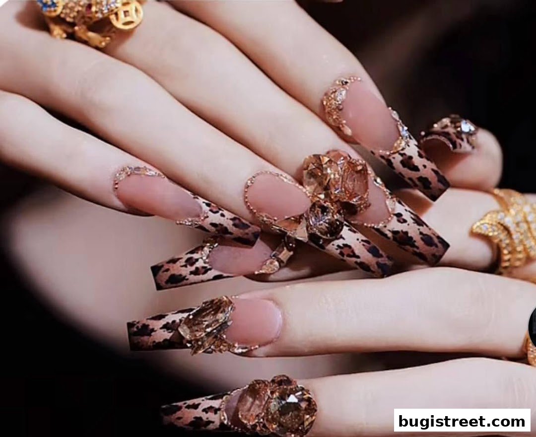 Close-up of hands with elaborate leopard print and jeweled acrylic nails.