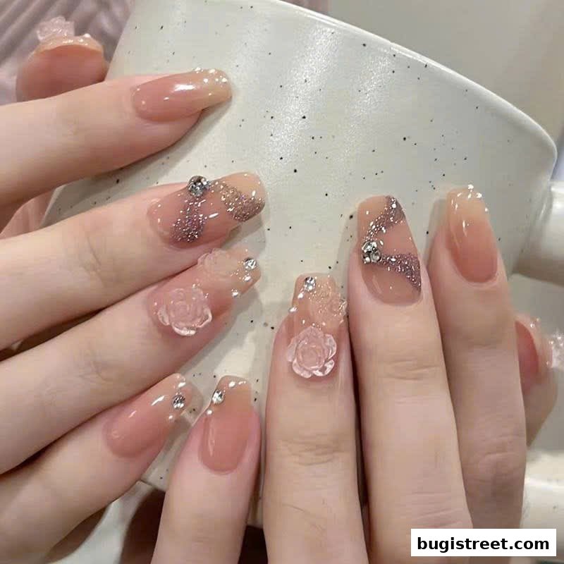 Close-up of hands with elegant, decorated nails featuring 3D flowers and glitter.