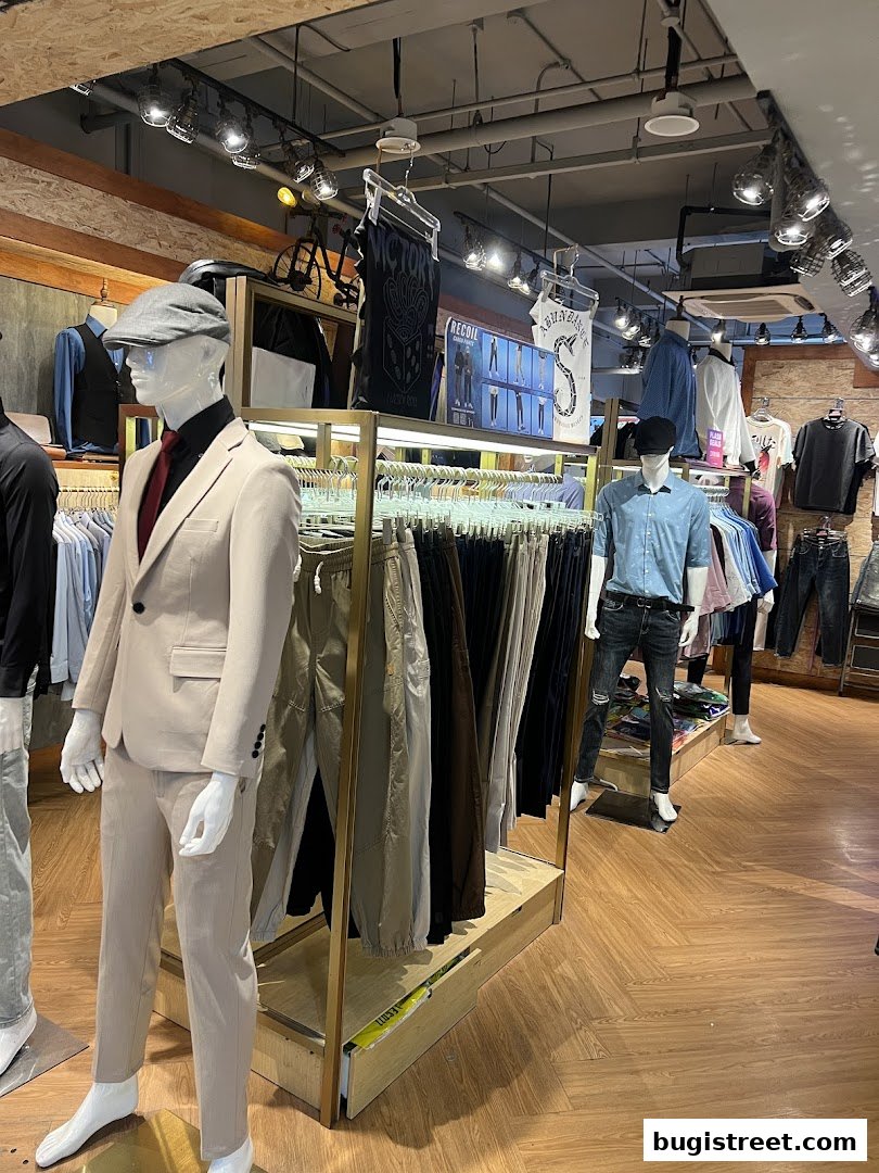 Mannequins display stylish suits and casual wear inside a clothing store.
