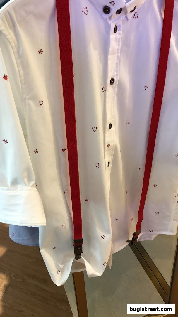 A white shirt with a small red star pattern and red suspenders.