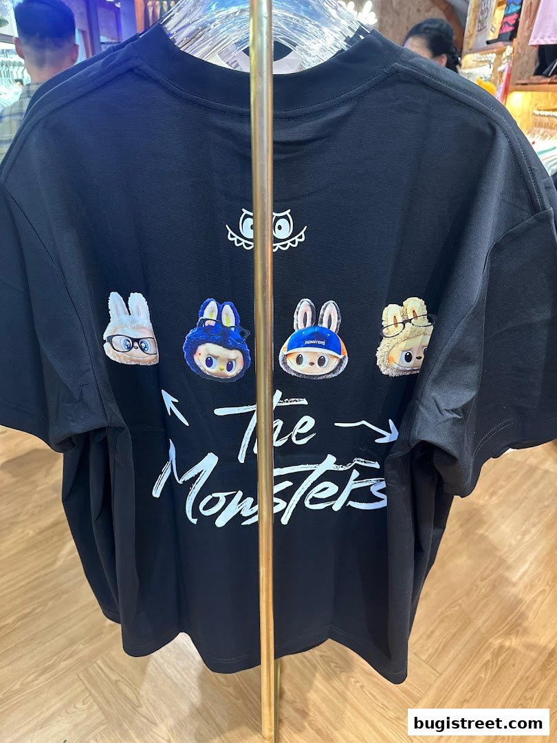 A black t-shirt with a graphic print of cartoon characters and the text 'The Monsters'.