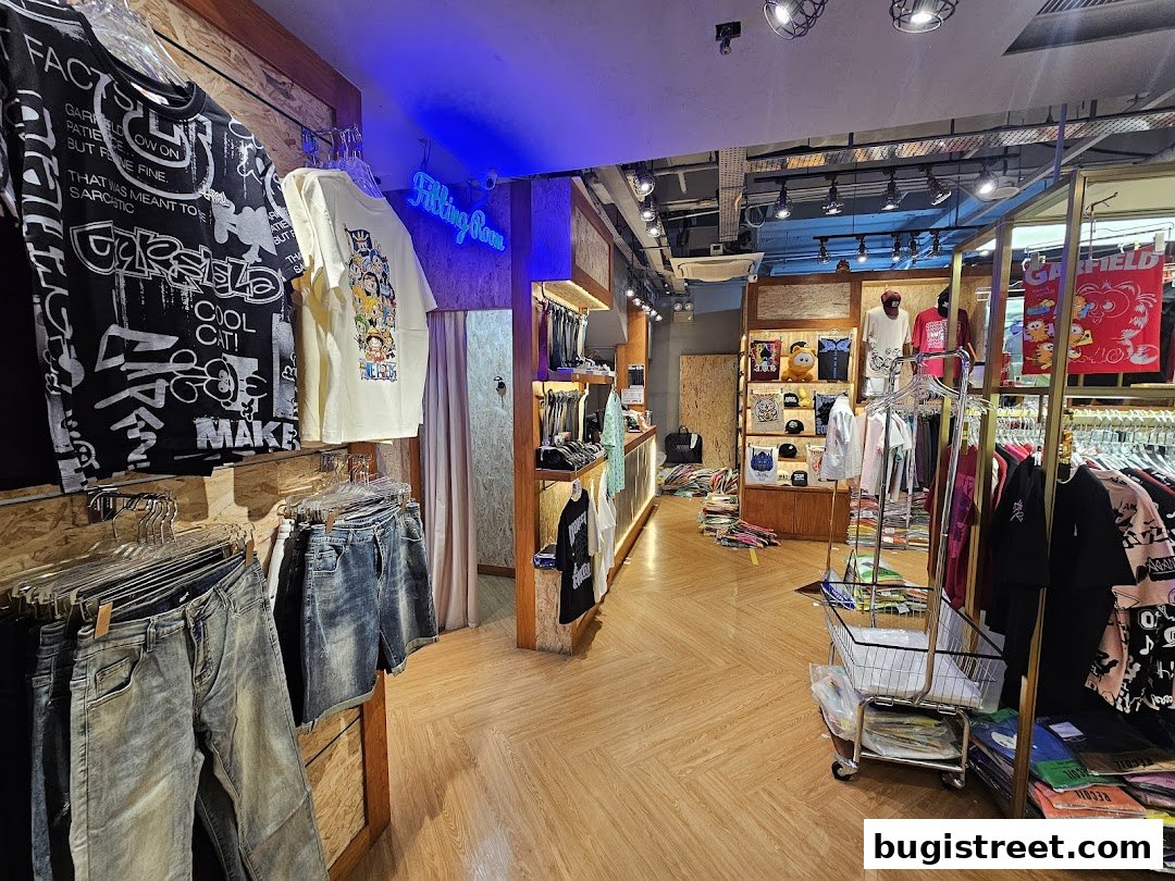 Interior view of a clothing store showcasing graphic t-shirts, denim shorts, and jeans.