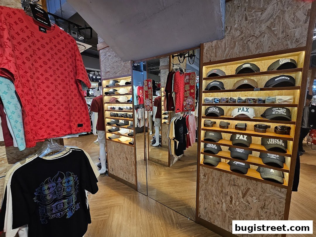 A retail shop interior displaying branded apparel, caps, and accessories on shelves and racks.