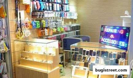 A shop interior displaying phone accessories and a sign for repairing and accessories.