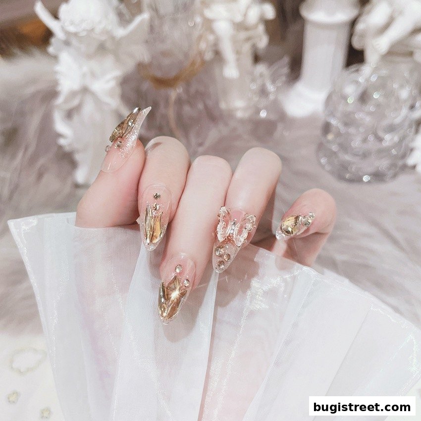 A close-up of a hand showcasing elaborate, crystal-embellished nails with butterfly and metallic accents.