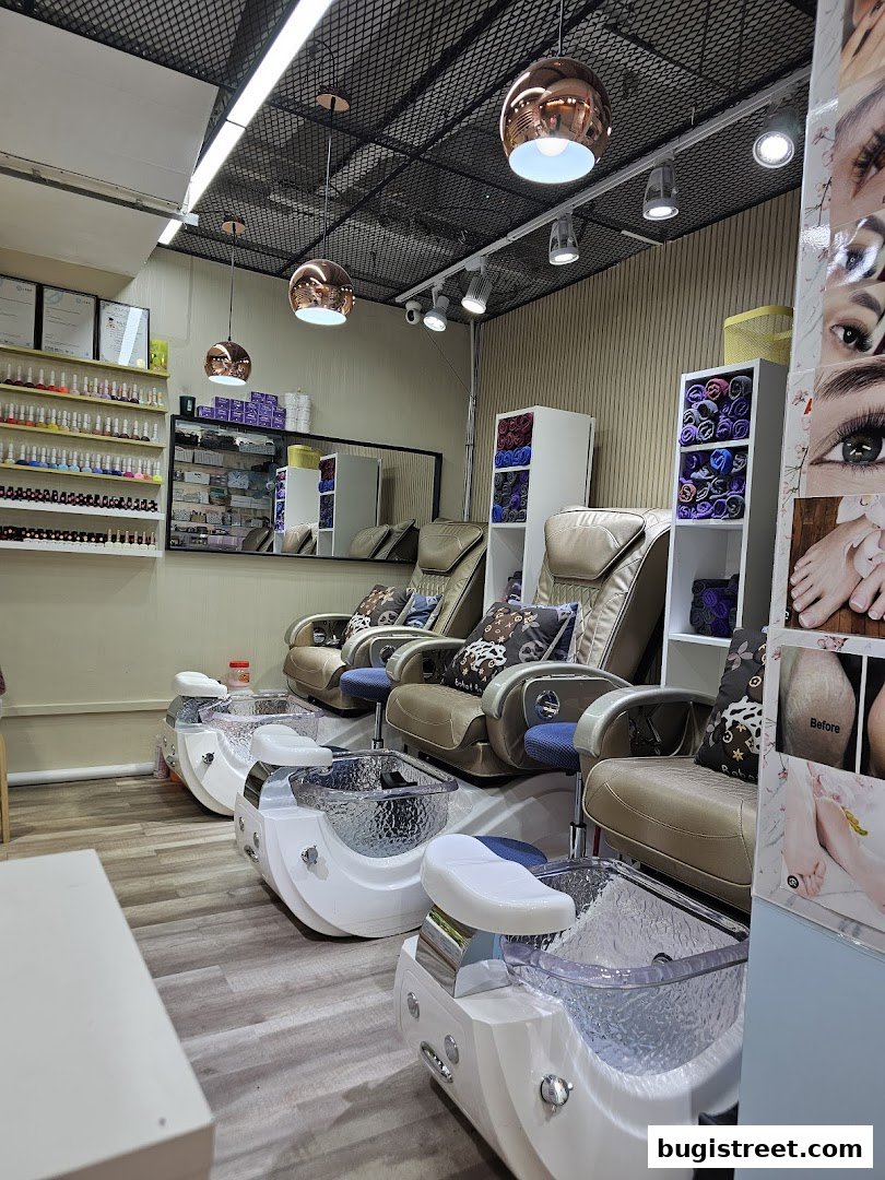 Interior of a nail salon with pedicure chairs, nail polish display, and decorative elements.