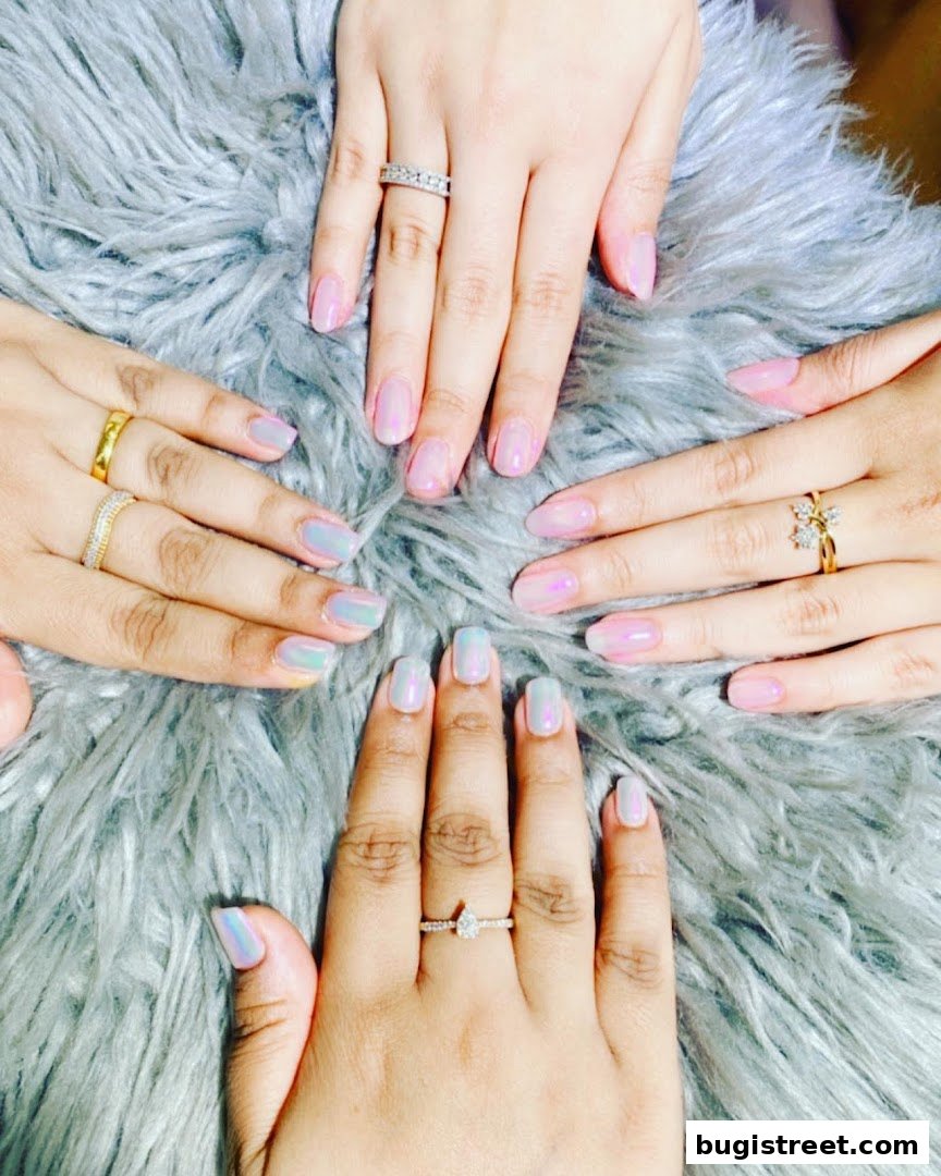 Close-up of four hands with beautifully manicured nails and rings.