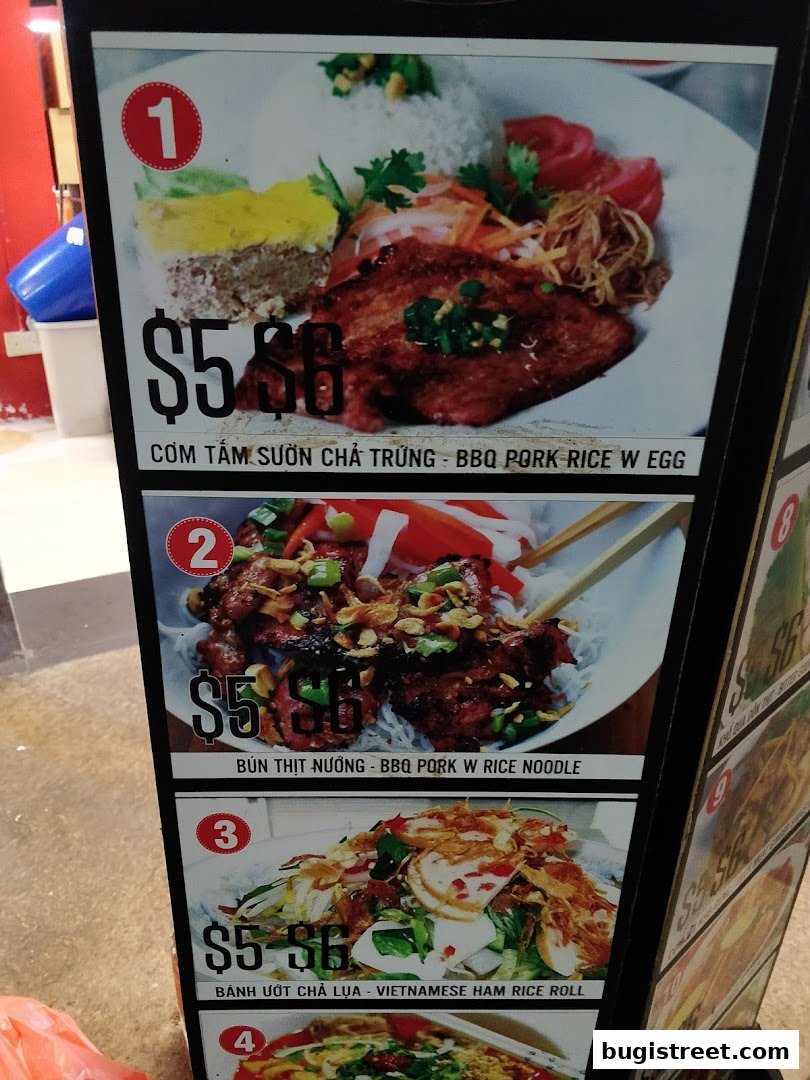 A display board showcasing Vietnamese dishes with prices and descriptions.