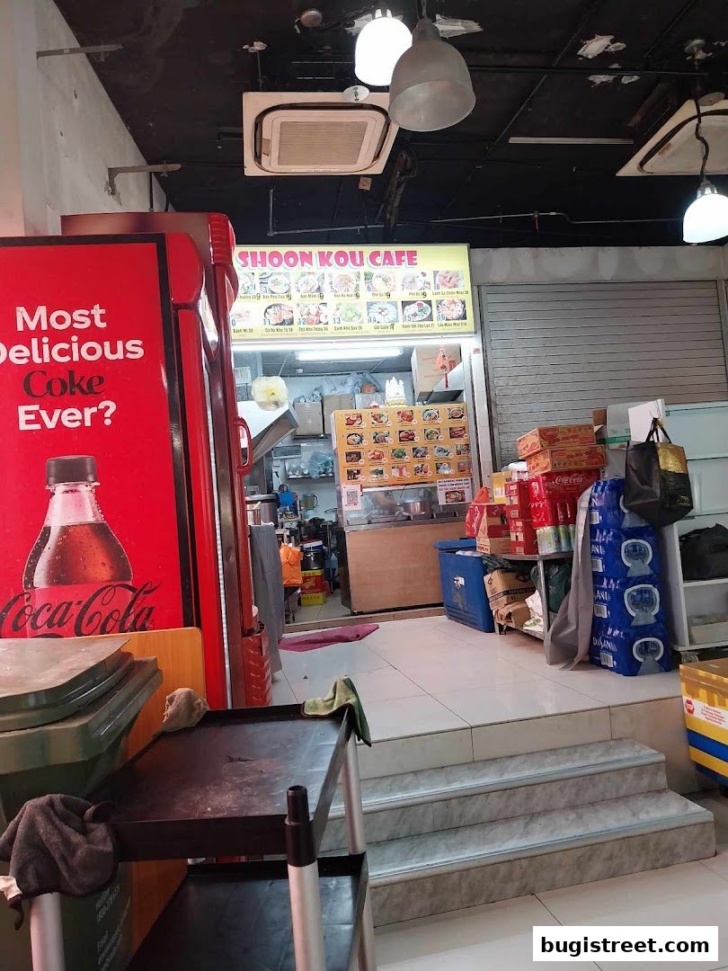 The entrance to Shoon Kou Cafe, featuring a Coca-Cola advertisement and a menu board.
