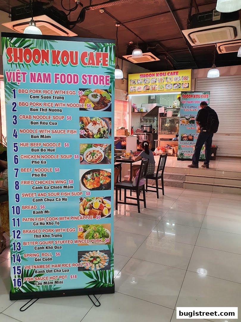 A colorful menu board for Shoon Kou Cafe, a Vietnamese food store, displaying various dishes and prices.