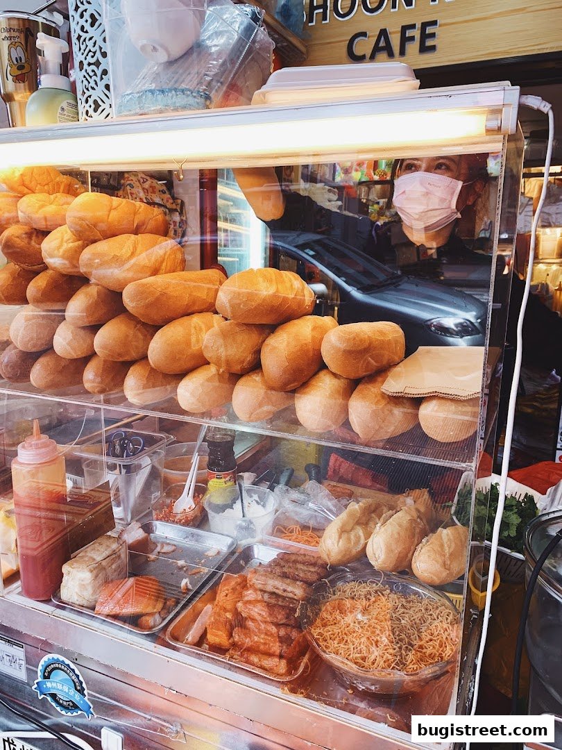 A display case filled with fresh bread, meats, and noodles at Shoon Kou Cafe.