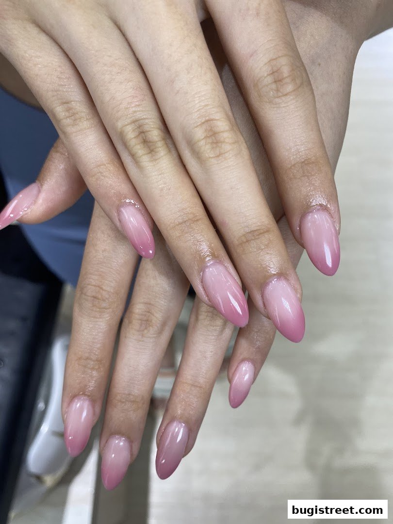 Close-up of hands with perfectly manicured ombre pink and white nails.