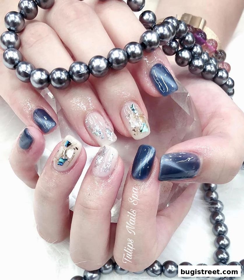 Close-up of hands with intricate nail art, featuring pearl bracelets and a crystal.