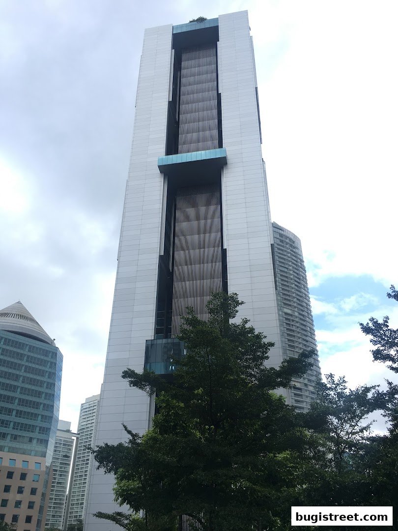 A tall, modern skyscraper with a unique architectural design against a cloudy sky.