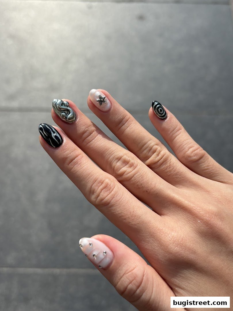 A close-up of a hand showcasing intricate nail art with various designs and embellishments.