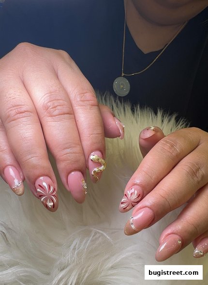 Close-up of hands with intricately designed nails featuring snake and floral patterns.