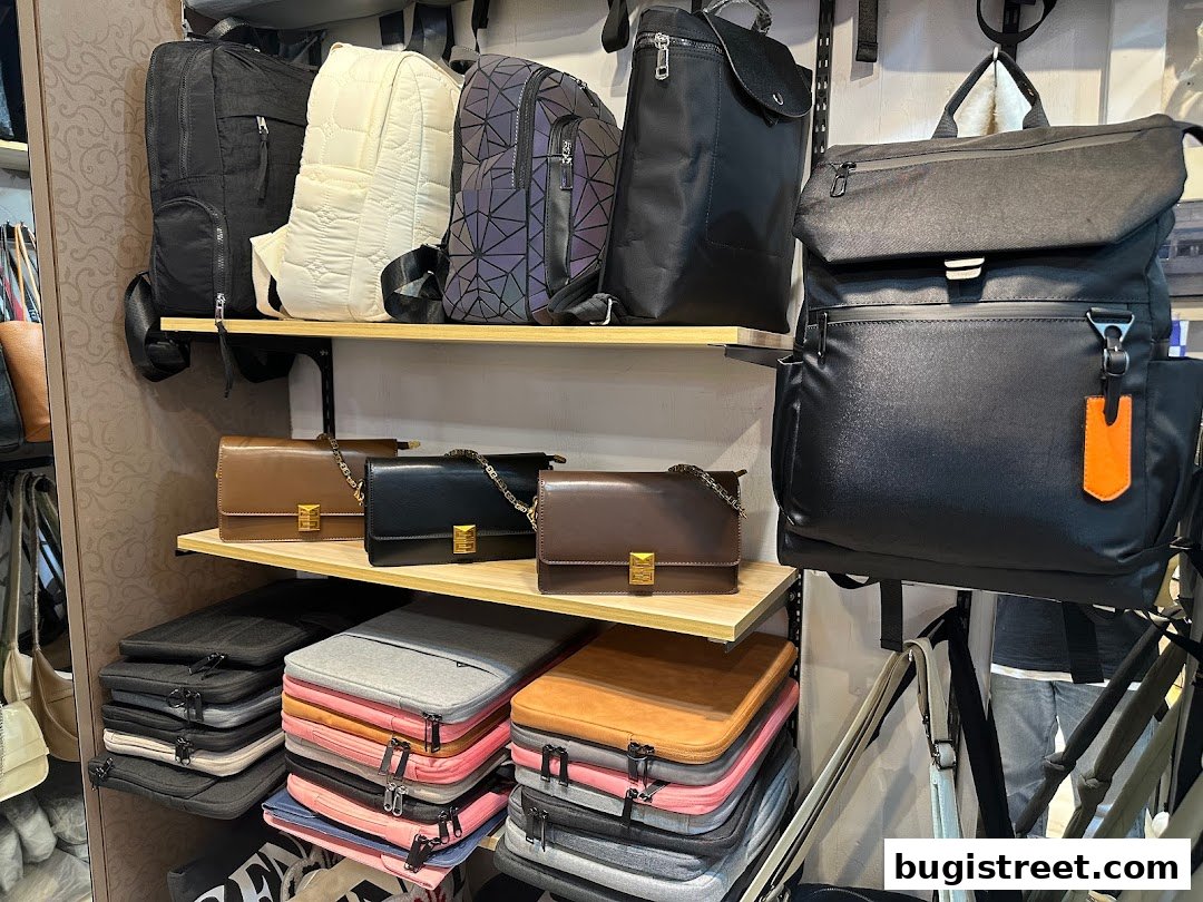 A retail shop display featuring various backpacks, handbags, and laptop sleeves.